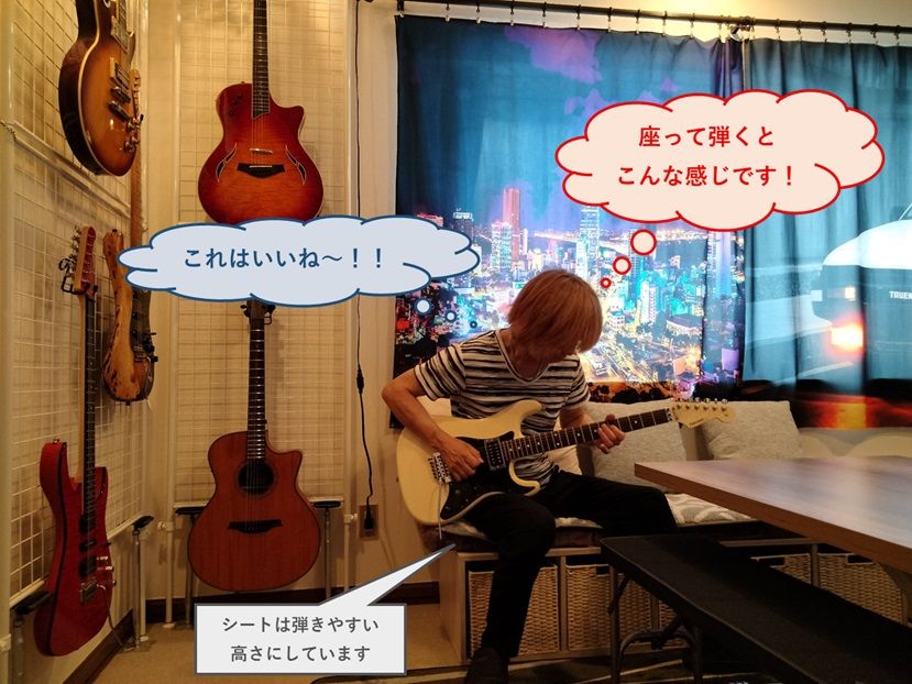 ソファに座ってギターを弾いている様子